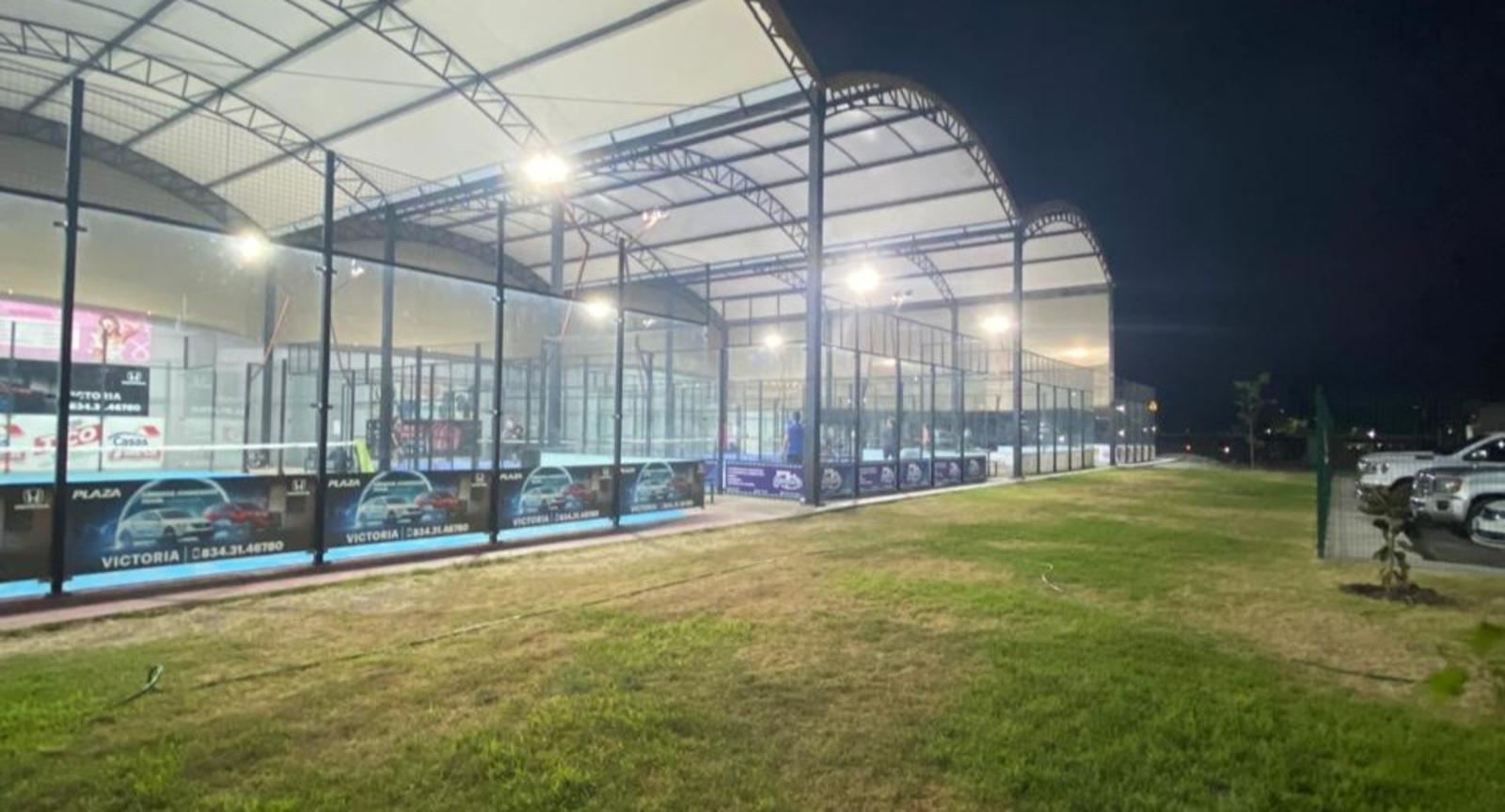 Vista exterior de las canchas techadas del club por la noche